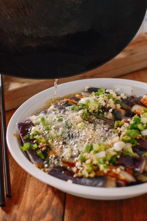 Pouring hot oil over steamed eggplant with garlic and scallions, thewoksoflife.com