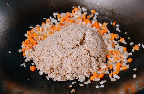 Adding cooked brown rice to carrots and onions, thewoksoflife.com