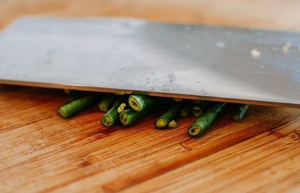 Crushing long beans with knife, thewoksoflife.com