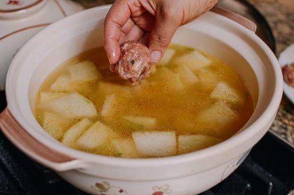 Lowering meatballs into soup, thewoksoflife.com