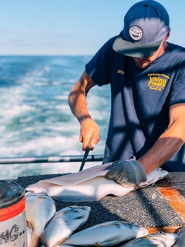 Filleting fluke on boat, thewoksoflife.com