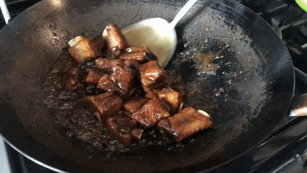 Reducing the sauce to coat pork ribs, thewoksoflife.com