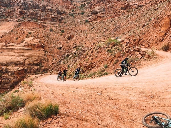 Mountain bikers walking on Schafer trail on White Rim trail Moab Utah by thewoksoflife.com