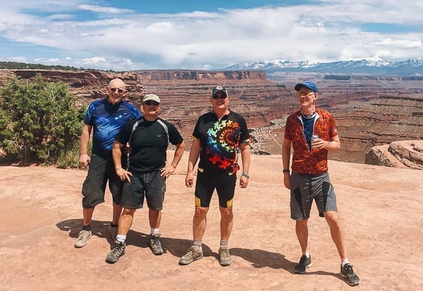 Mountain bikers group photo at top of Schafer trail on White Rim trail Moab Utah by thewoksoflife.com