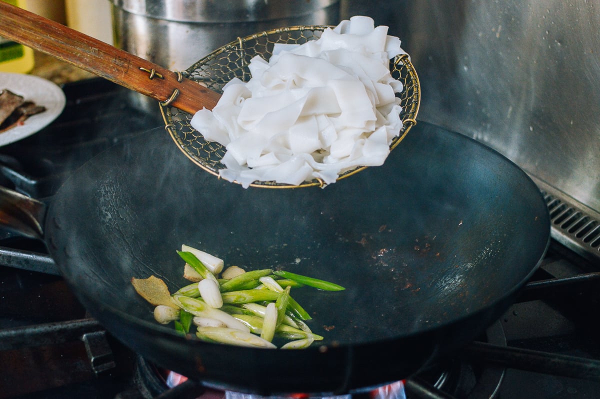 Adding rice noodles to wok, thewoksoflife.com