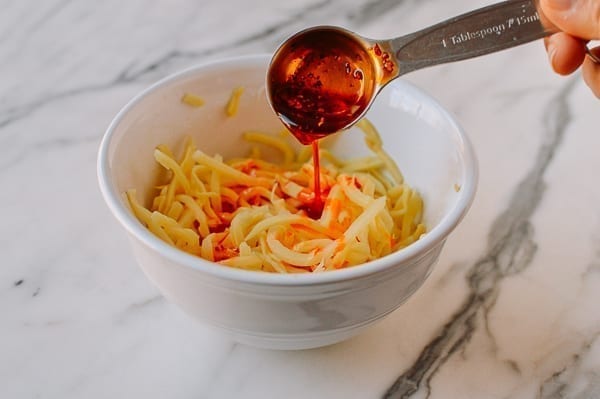 Adding chili oil to bamboo shoots, thewoksoflife.com