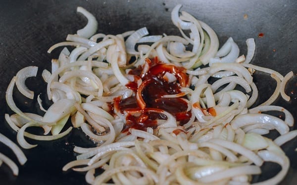 Adding sauce to onions, thewoksoflife.com