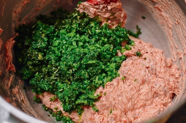 Mixing in chopped watercress and cilantro, thewoksoflife.com