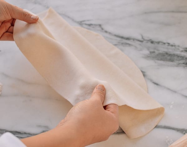 Folding dough to make layers, thewoksoflife.com