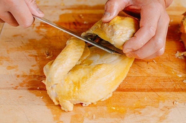 Removing thigh from chicken half, thewoksoflife.com
