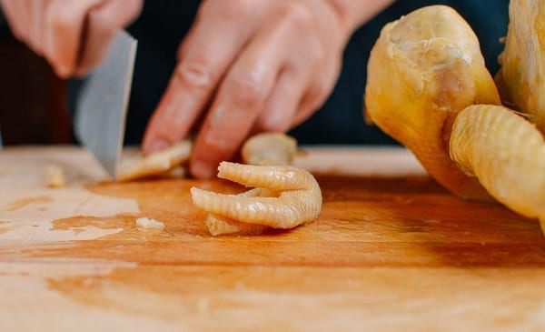 Trimming chicken feet on a white cut chicken, thewoksoflife.com