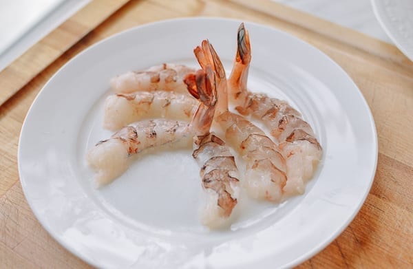 Three halved shrimp arranged on a plate with tails sticking up