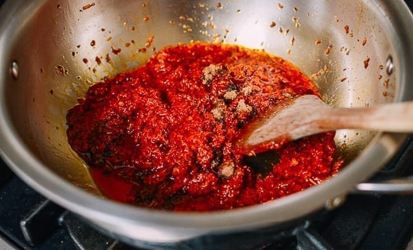 Stirring in laksa paste and brown sugar, thewoksoflife.com