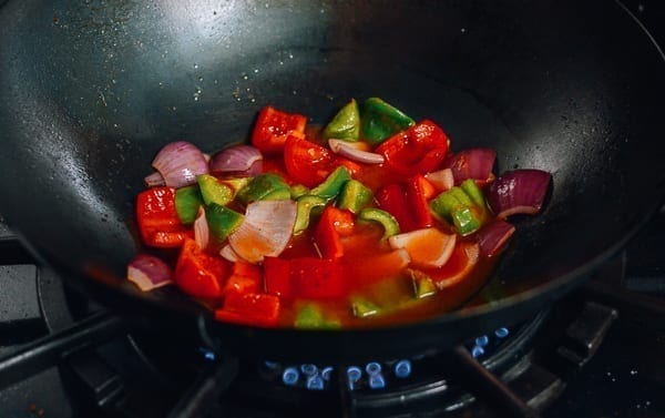 Adding sweet and sour sauce to onions and peppers, thewoksoflife.com