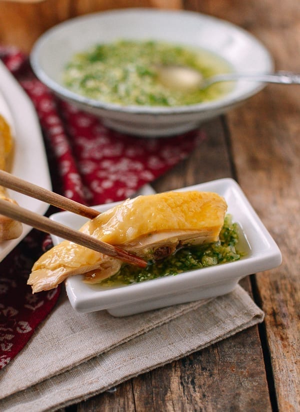 Dipping white cut chicken into ginger scallion sauce, thewoksoflife.com