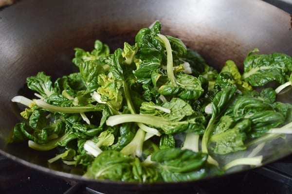 Adding tatsoi to wok, thewoksoflife.com