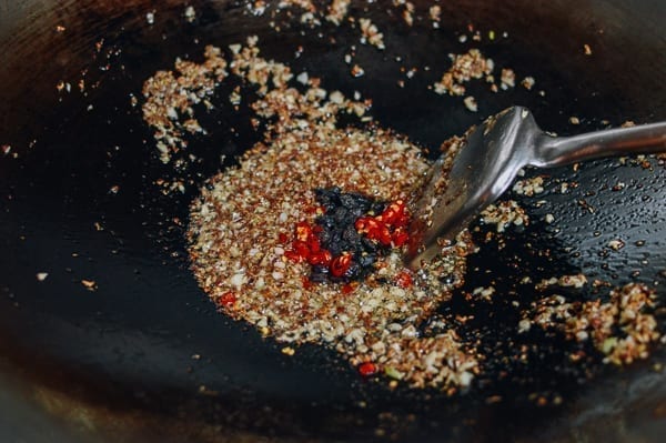 Adding fermented black beans and chilies, thewoksoflife.com