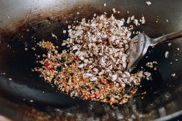 Adding chopped mushrooms to wok, thewoksoflife.com