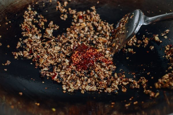 Adding chili oil and spicy bean sauce, thewoksoflife.com