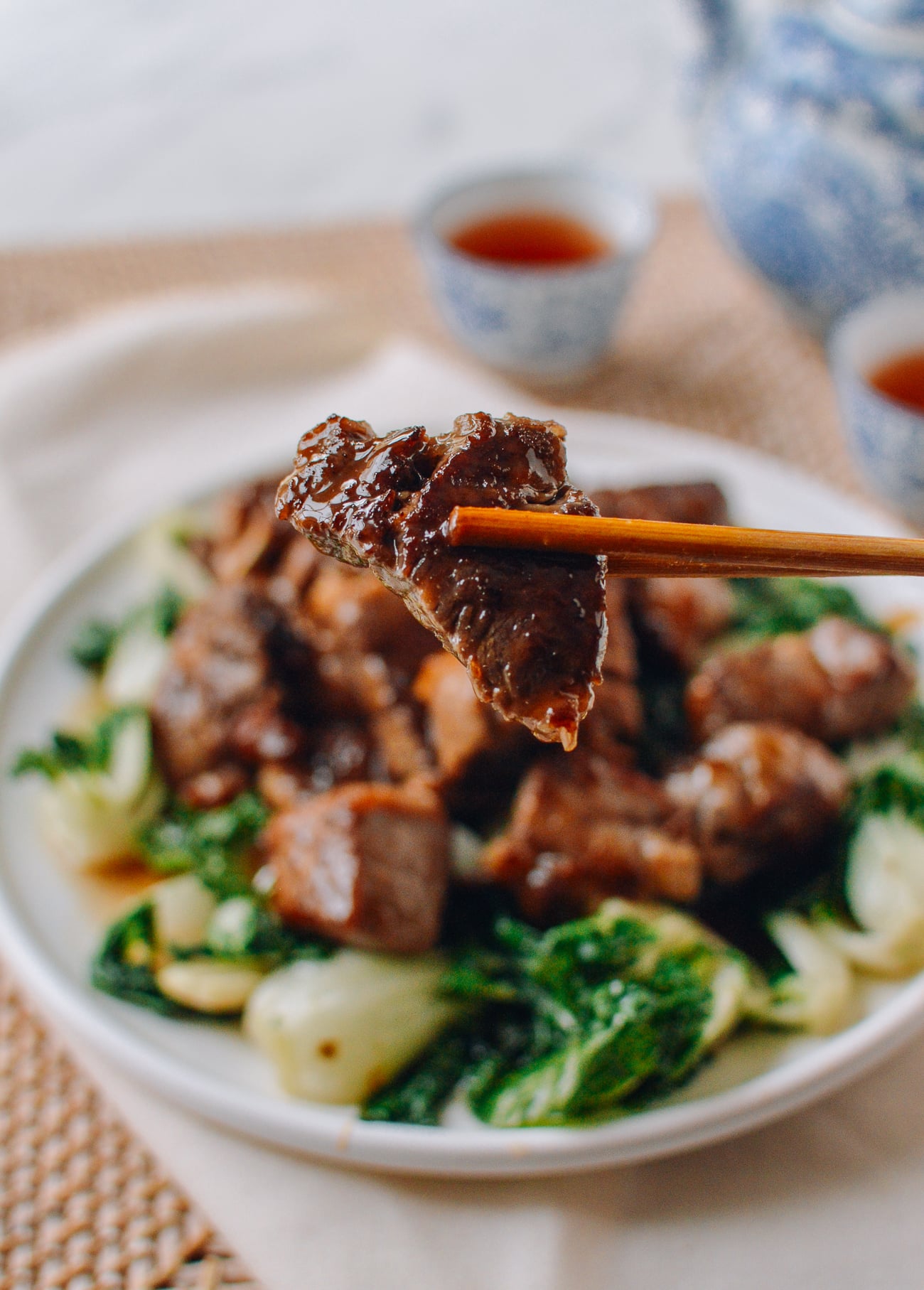 Chopsticks holding chunk of steak