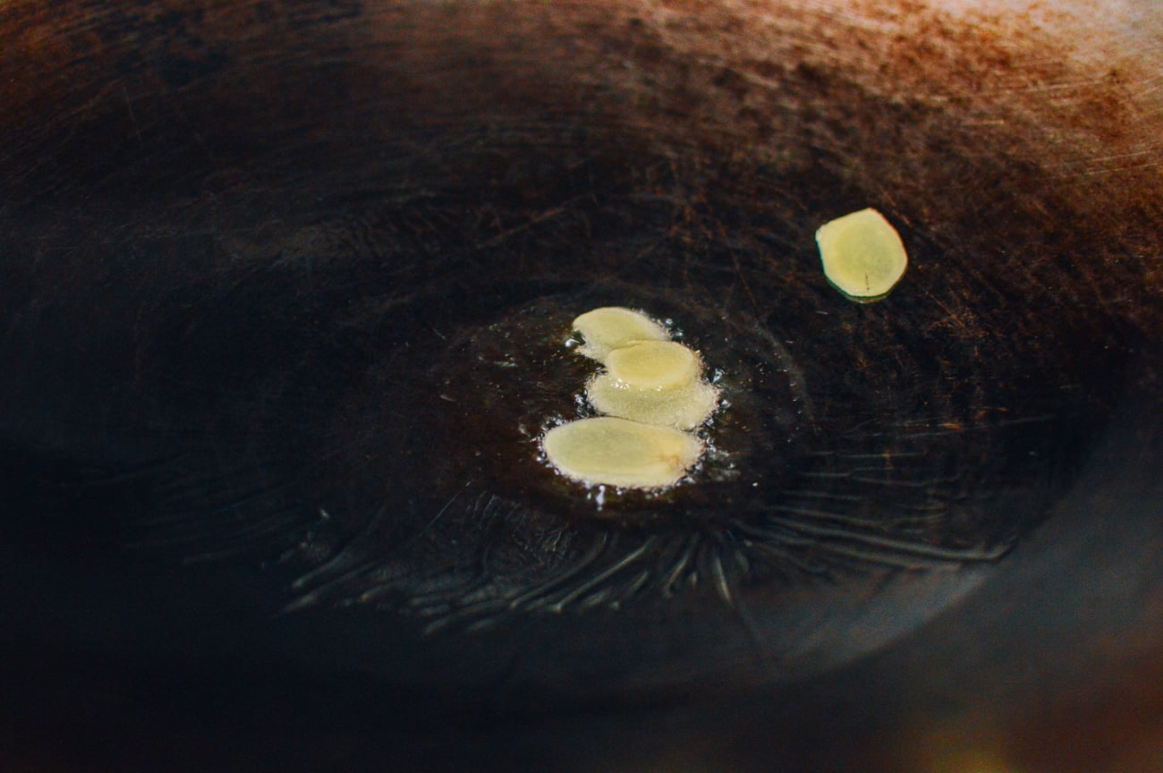 ginger slices in oil in wok