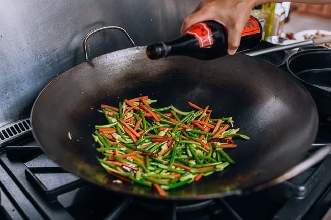 Adding Shaoxing wine to the wok