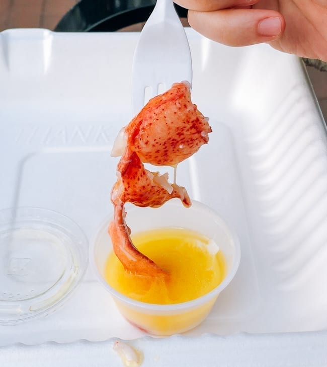 Dipping lobster into cup of butter, thewoksoflife.com