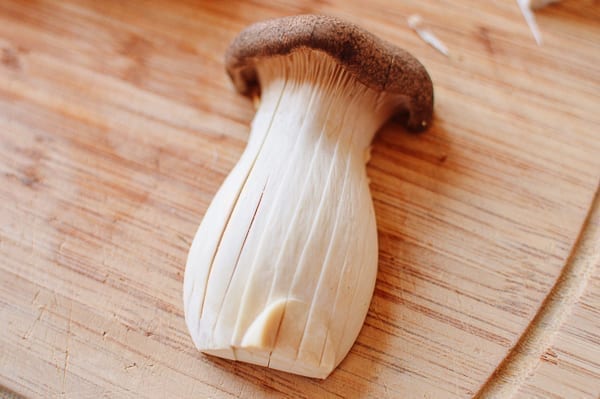 Scoring king oyster mushroom lengthwise, thewoksoflife.com