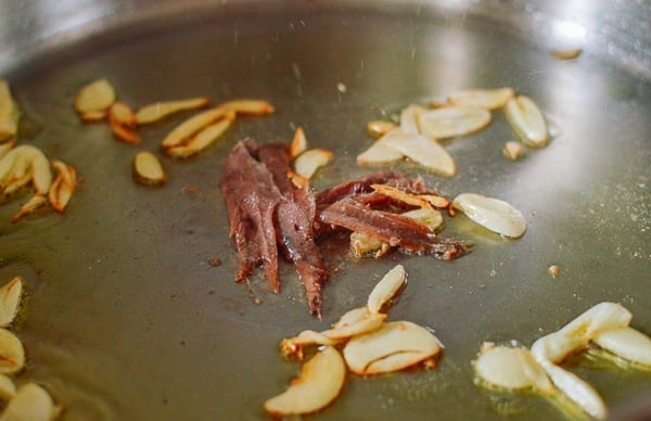 Adding anchovies to garlic, thewoksoflife.com