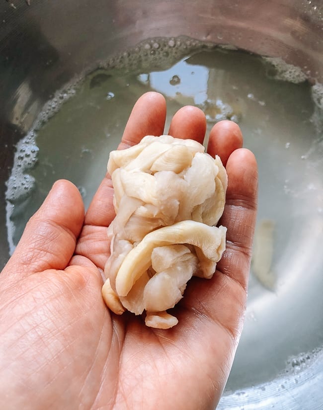 Squeezing water out of the dried daikon, thewoksoflife.com