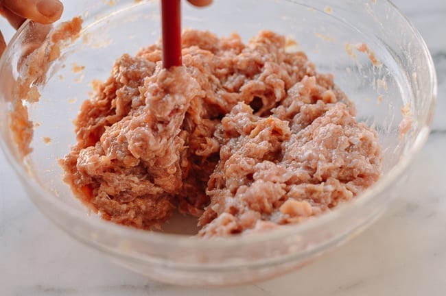 Stirring Chinese meat mixture until it resembles a paste, thewoksoflife.com