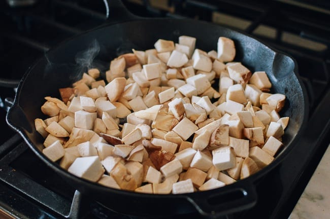 Adding mushrooms to cast iron pan, thewoksoflife.com
