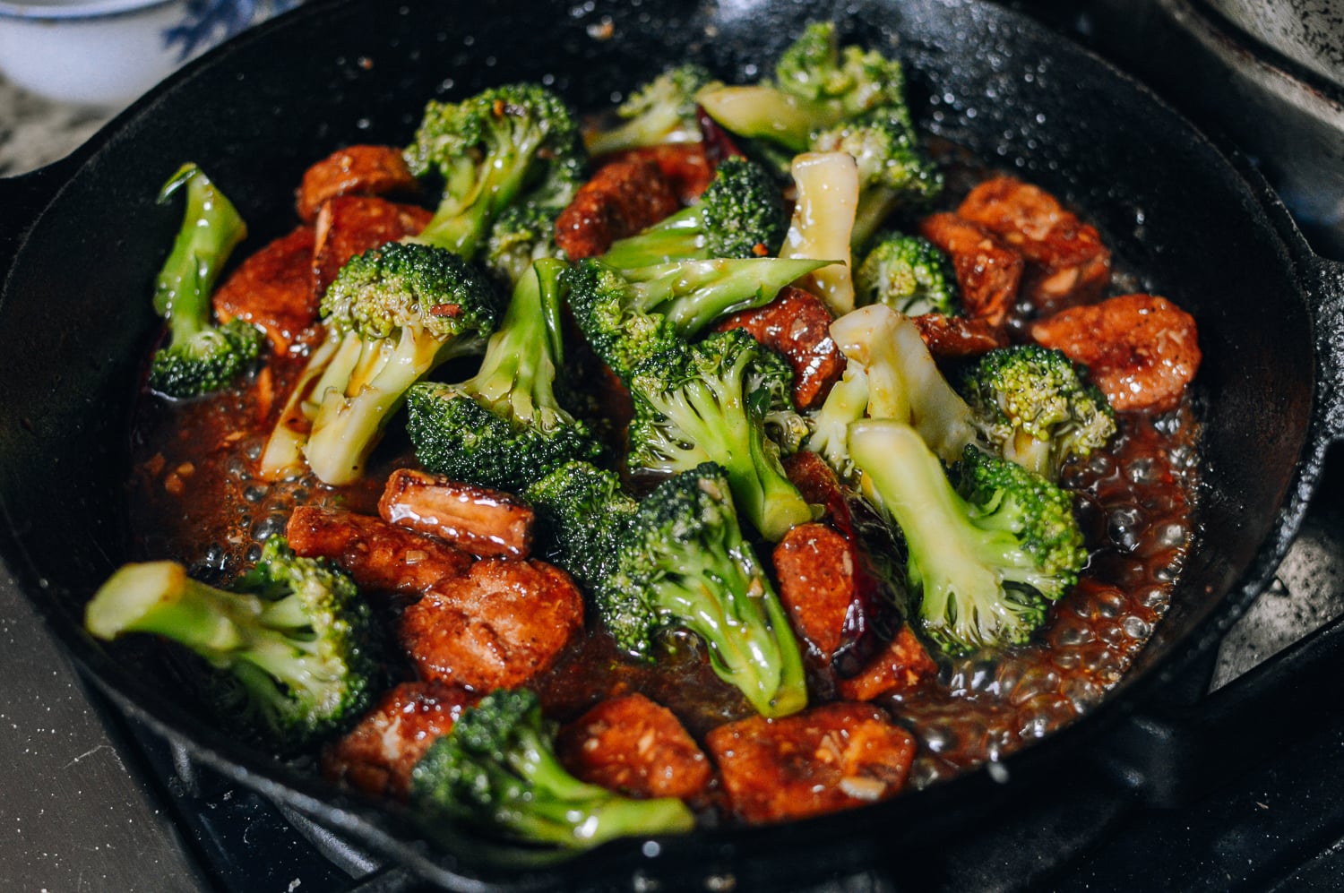 Tossing broccoli and nuggets in sauce, thewoksoflife.com