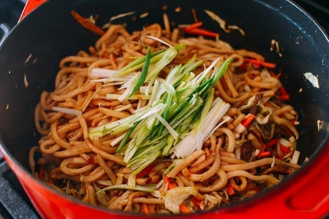Adding noodles and scallions pack to pot, thewoksoflife.com
