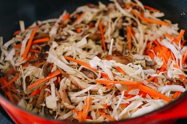 Adding vegetables to yaki udon mixture, thewoksoflife.com