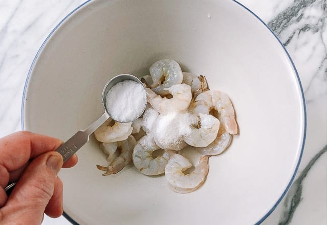 Adding marinade ingredients to shrimp, thewoksoflife.com