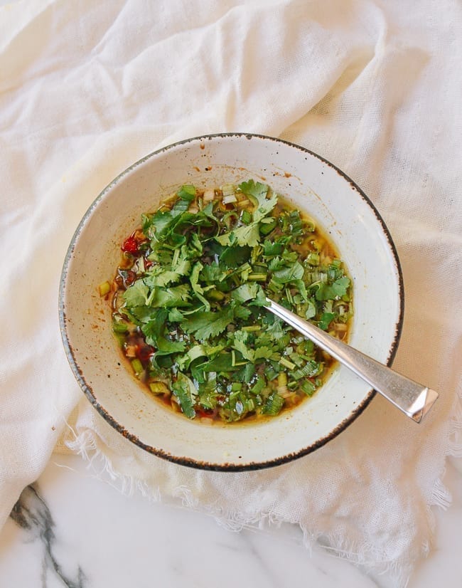 Stirring scallions and cilantro into sauce, thewoksoflife.com