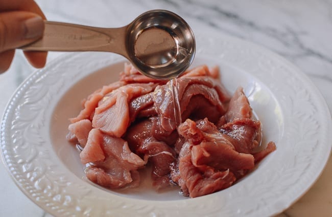 Adding water, Shaoxing wine, oyster sauce, thewoksoflife.com