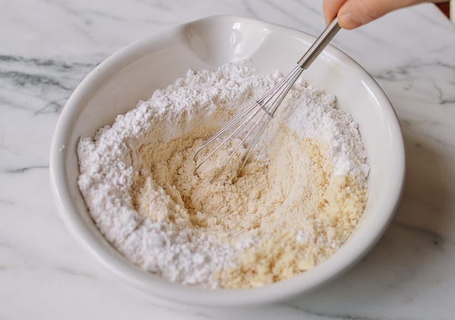 Whisking together almond flour, self-rising flour, and salt, thewoksoflife.com