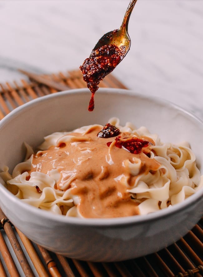 Adding extra chili oil to peanut noodles, thewoksoflife.com