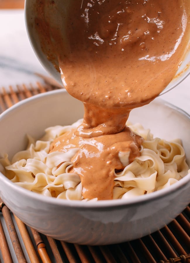 Pouring sauce over noodles, thewoksoflife.com