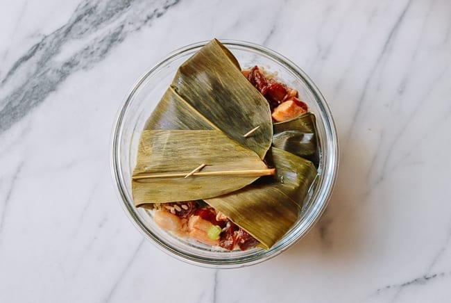 Covering sticky rice with bamboo leaves, thewoksoflife.com