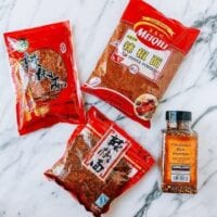 Sichuan chili flakes next to regular crushed red pepper, thewoksoflife.com