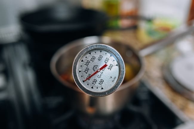 Monitoring oil temperature with thermometer, thewoksoflife.com