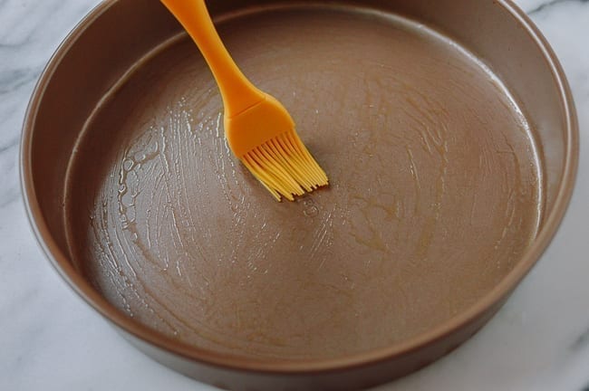Brushing cake pan with oil, thewoksoflife.com
