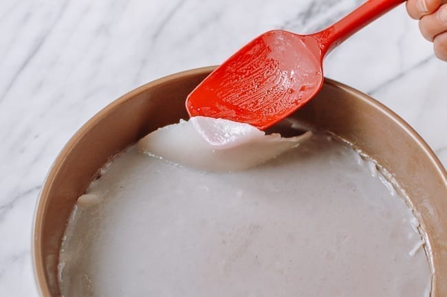 Removing noodle from oiled pan with rubber spatula, thewoksoflife.com
