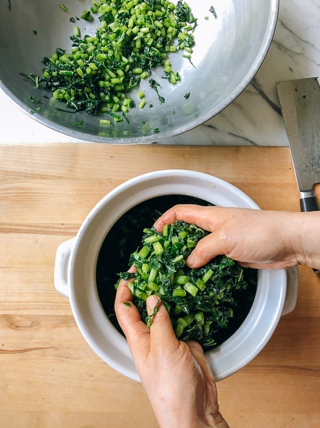 Transferring salted greens to a container, thewoksoflife.com