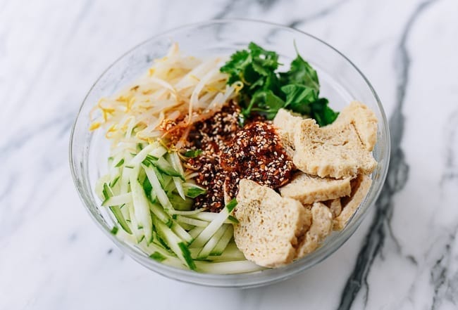 Adding sauce to bowl of ingredients, thewoksoflife.com