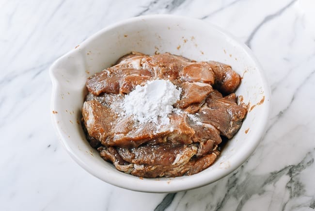 Adding potato starch and water to marinated Taiwan pork chops, thewoksoflife.com