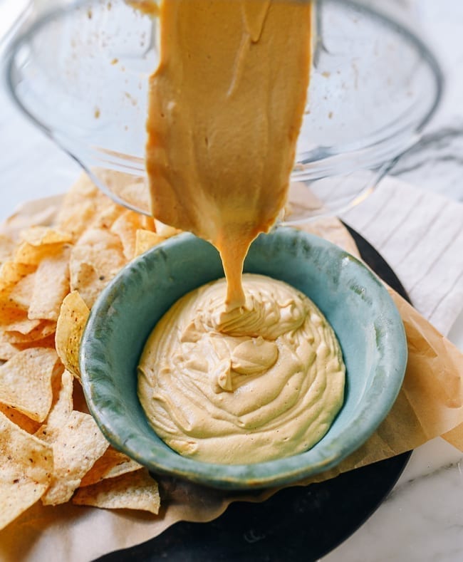 Transferring vegan queso from blender to bowl, thewoksoflife.com
